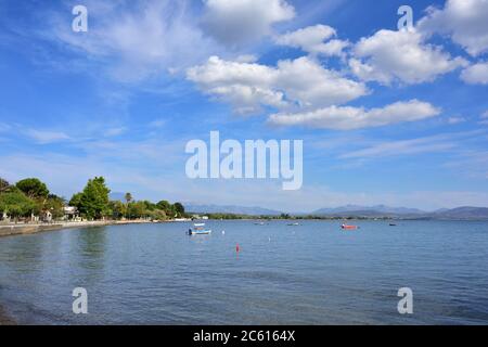 Schöne Aussicht auf Paralia Politikon Bucht. Bunte Fischerboote auf blauem Wasser, Ägisches Meer, Chalcis, Griechenland Stockfoto