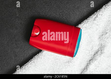 Ein rotes Deo-Deo mit blauem Gel liegt auf einem schwarzen Tischstick und einem weißen Handtuch. Mocap, Draufsicht, Nahaufnahme, Kopierbereich Stockfoto