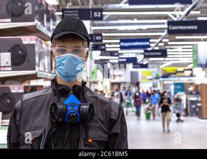 Männliche Schaufensterpuppe in Arbeitskleidung mit einer schützenden medizinischen Maske auf seinem Gesicht. Stockfoto