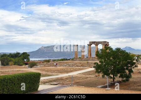 Altes Korinth und Blick auf den Tempel von Apollo unter dramatischem bewölktem Himmel bei Sonnenuntergang in Griechenland Stockfoto