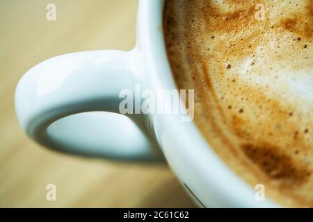 Tasse frisch zubereitetes Arabica-Kaffee-Cappuccino. Barista-Thema. Nahaufnahme Foto. Stockfoto