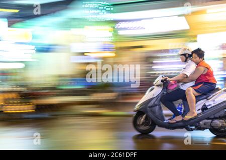 Ein rasender Motorrad in einem asiatischen Stadtzentrum Stockfoto