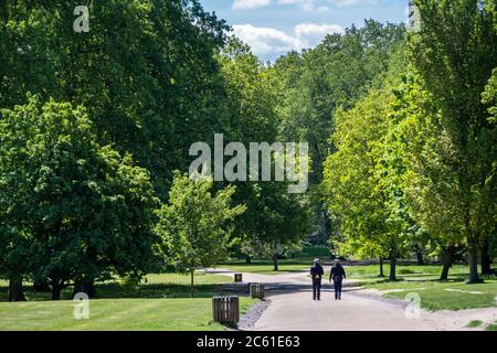 Großbritannien, England, London, Westminster, Green Park. Zwei Polizisten gehen auf einem Pfad durch einen leeren Green Park neben dem Buckingham Palace Stockfoto