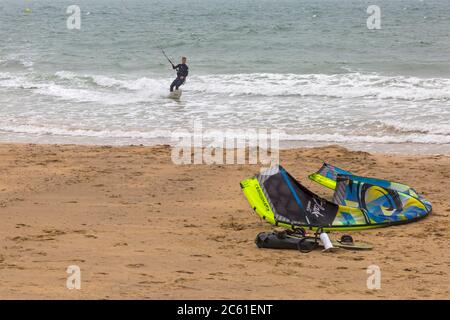 Kitesurfer Kitesurfen mit einem anderen Kite am Strand in Bournemouth, Dorset UK an windigen Nieseltag im Juli - Kitesurfer Kitesurfen Stockfoto