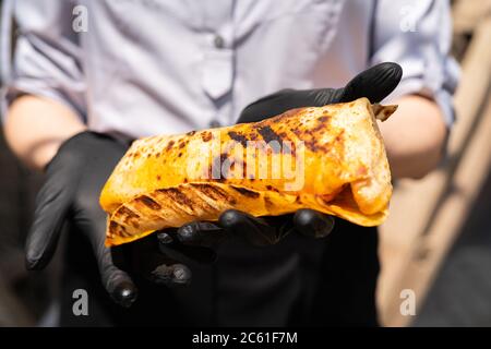 Burrito, Lamm Shawarma - das beste Street Food. Nahaufnahme von Frauen Hände Köche mit Shawarma. Stockfoto