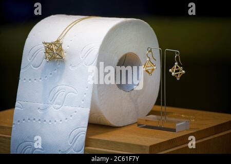 Köln, Deutschland. April 2020. Neben einer Rolle Toilettenpapier im Schaufenster eines Goldschmieds sind eine Halskette und Ohrringe zu sehen. Ein Kölner Goldschmied hat diese Idee aufgrund des zu Beginn der Corona-Pandemie fehlenden Toilettenpapier umgesetzt und ist nun Teil einer Museumsausstellung geworden. Die aktuelle Wechselausstellung 'Pure Luxury' im Museum beschäftigt sich unter anderem mit der Frage, was während der Corona-Krise unerwartet Luxus wurde. Quelle: Henning Kaiser/dpa/Alamy Live News Stockfoto