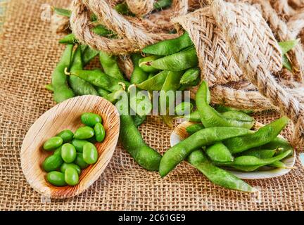 Edamame oder Sojabohnen in einem Holzteller auf einem braunen Sacktuch. Stockfoto