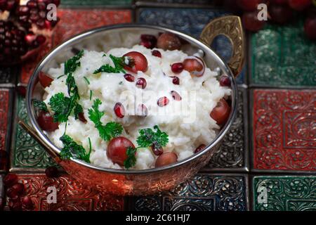 Südindischer Yougurt-Reis mit Trauben und Granatapfel in traditioneller Servierschüssel Stockfoto