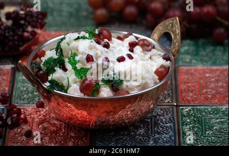 Südindischer Yougurt-Reis mit Trauben und Granatapfel in traditioneller Servierschüssel Stockfoto