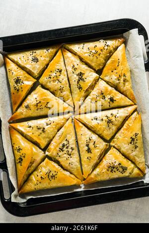 Gebacken im Ofen indischen Samosa mit Phyllo mit würzigen Kartoffeln und Gemüse mit schwarzen Sesam. Street traditionellen Fast Food Stockfoto