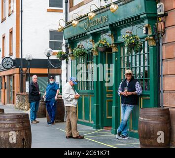 Leith, Edinburgh, Schottland, Großbritannien, 6. Juli 2020. Cafe Kultur & Pub Eröffnung beginnt: Cafés und Pubs entlang der Küste beginnen, Straßenpflaster für Mahlzeiten und Getränke bieten und die Gegend fühlt sich viel geschäftiger als in den letzten Monaten. Pub Biergärten und Außenbereiche können ab heute in Schottland geöffnet. James genießt ein Bier, das draußen im traditionellen Pub Malt & Hops steht Stockfoto