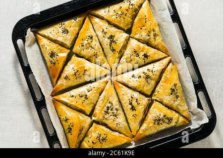 Gebacken im Ofen indischen Samosa mit Phyllo mit würzigen Kartoffeln und Gemüse mit schwarzen Sesam. Street traditionellen Fast Food Stockfoto