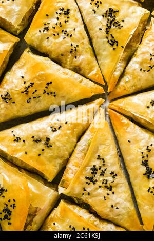 Gebacken im Ofen indischen Samosa mit Phyllo mit würzigen Kartoffeln und Gemüse mit schwarzen Sesam. Street traditionellen Fast Food Stockfoto