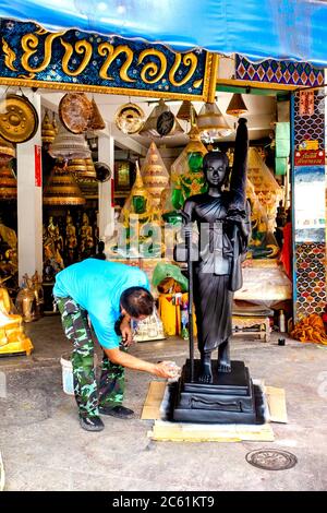 Mann, der eine Statue in Bamrung Mueang Road, Bangkok, Thailand, malt, Stockfoto