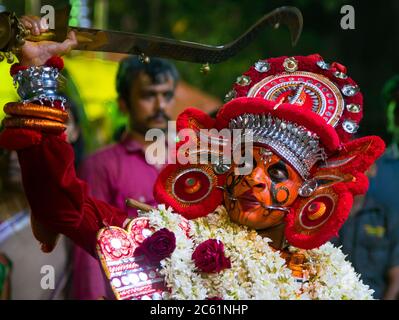 Die rituelle Kunst Form von Kerala, Thyra oder Theyyam thira ist ein ritueller Tanz, der in 'Kaavu'(Hain)& Tempeln des Kerala, Indien, aufgeführt wird Stockfoto