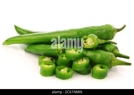 Bund frischer grüner Chilischoten und zwei Hälften auf weißem Hintergrund Stockfoto