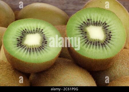 Grüne Kiwi-Frucht in einer Holzkiste auf weißem Hintergrund Stockfoto