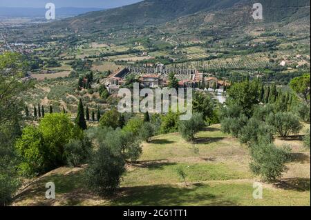 Luftaufnahme einer kleinen alten Mauer geschlossenen Friedhof zwischen Olivenbäumen im Tal am Fuße der Hügel in der Toskana, Cortona Stockfoto