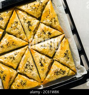 Gebacken im Ofen indischen Samosa mit Phyllo mit würzigen Kartoffeln und Gemüse mit schwarzen Sesam. Street traditionellen Fast Food Stockfoto