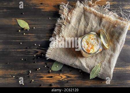 Fermentiertes Gemüse. Sauerkraut. Karotten, Pfeffer, Lorbeer-Zutaten auf Holzgrund Stockfoto