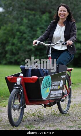 Erfurt, Deutschland. Juli 2020. Anja Siegesmund (Bündnis90/die Grünen) Umweltministerin Thüringens, fährt mit dem Lastenrad durch den Beethovenpark. Am selben Tag stellte der Umweltminister die neue Richtlinie Cargobike Invest (Lastenrad-Förderung) vor. Erstmals wird in Thüringen der Kauf dieser klimafreundlichen Transportalternative zum Auto unterstützt. Maximal sind bis zu 3,000 EUR pro Rad möglich. Quelle: Martin Schutt/dpa-Zentralbild/dpa/Alamy Live News Stockfoto