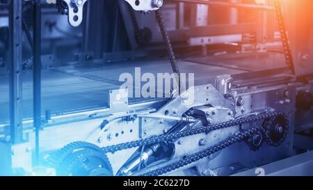 Industrie Hintergrund, leeres Industrie Förderband mit Metallketten und Mechanismen in blauer Farbe und roten und blauen Lichteffekten, Kopierraum für Text. Stockfoto
