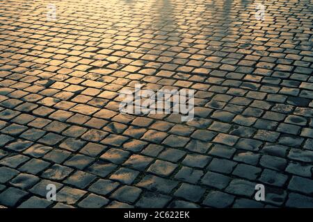 Pflastersteine bei Sonnenuntergang, alte europäische Straße Hintergrund. Stockfoto