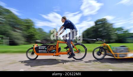 Erfurt, Deutschland. Juli 2020. Tobias Hage von der Erfurter Lastenrad-Initiative 'Ella' fährt mit einem Lastenrad mit Anhänger durch den Beethovenpark. Am selben Tag stellte Thüringens Umweltminister die neuen Leitlinien der Cargobike Invest (Lastenrad-Förderung) vor. Erstmals wird in Thüringen der Kauf dieser klimafreundlichen Transportalternative zum Auto unterstützt. Maximal sind bis zu 3,000 EUR pro Rad möglich. Quelle: Martin Schutt/dpa-Zentralbild/dpa/Alamy Live News Stockfoto