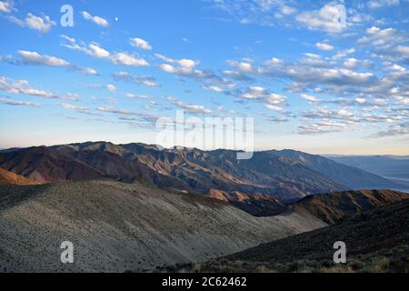 Sonnenuntergang in Dantes Blick über Death Valley. Blick nach Süden über die Amargosa Bergkette, während die Sonne hinter Wolken untergeht. Braune Wüstenberge Stockfoto