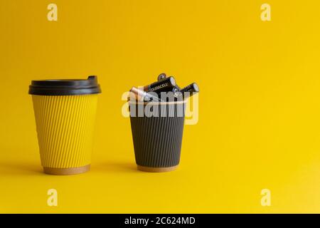 Zwei Pappbecher zum Mitnehmen, gelb mit Kaffee und Plastikabdeckung, Stockfoto