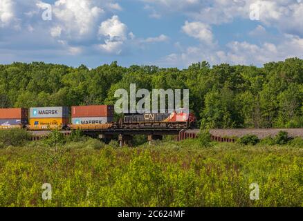 CN Güterzug durch eine ländliche Gemeinde im Norden Wisconsin. Stockfoto