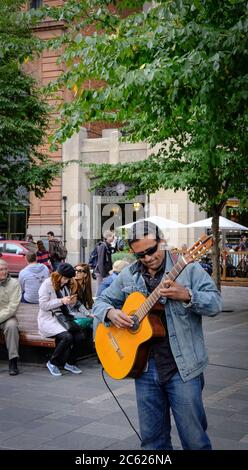 Feine akustische Gitarrist spielt für Mitglieder der Öffentlichkeit auf belebten Straßen Montreal im Herbst. Stockfoto