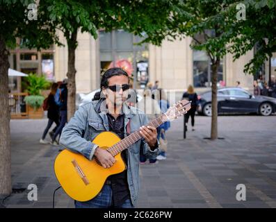 Feine akustische Gitarrist spielt für Mitglieder der Öffentlichkeit auf belebten Straßen Montreal im Herbst. Stockfoto