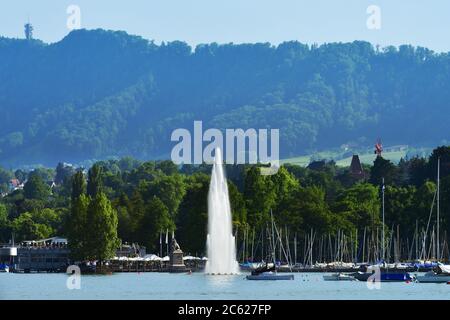Zürich, Schweiz - 14. Juni 2017: Wunderschöne Aussicht auf den Brunnen am Mythenquai im Zürichsee und das Stadtbild der Zürcher Altstadt bei Sonnenuntergang SW Stockfoto