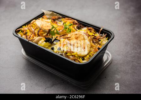 Restaurant Stil Ei Biryani oder Anda Pulao verpackt für die Hauslieferung in Plastikbox oder Container mit Raita und Salan Stockfoto