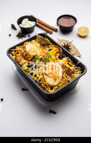 Restaurant Stil Ei Biryani oder Anda Pulao verpackt für die Hauslieferung in Plastikbox oder Container mit Raita und Salan Stockfoto