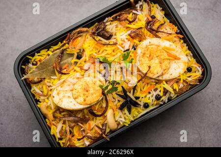 Restaurant Stil Ei Biryani oder Anda Pulao verpackt für die Hauslieferung in Plastikbox oder Container mit Raita und Salan Stockfoto