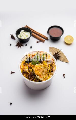 Restaurant Stil Ei Biryani oder Anda Pulao verpackt für die Hauslieferung in Plastikbox oder Container mit Raita und Salan Stockfoto