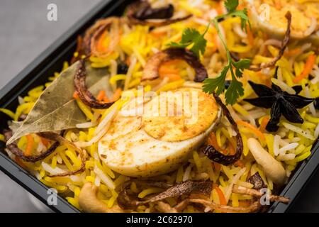 Restaurant Stil Ei Biryani oder Anda Pulao verpackt für die Hauslieferung in Plastikbox oder Container mit Raita und Salan Stockfoto