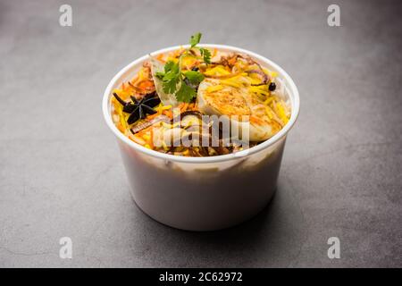 Restaurant Stil Ei Biryani oder Anda Pulao verpackt für die Hauslieferung in Plastikbox oder Container mit Raita und Salan Stockfoto