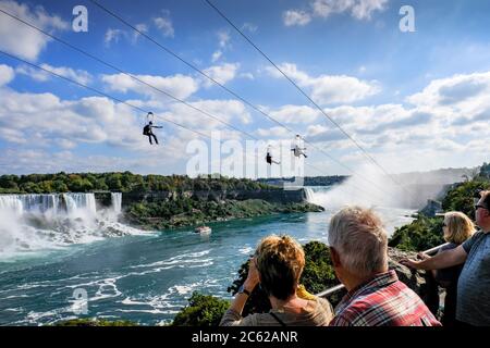 Landschaftlich reizvolle Aussicht auf die öffentlichen Drahtschienen neben den berühmten Niagara Fällen in Kanada. Man sieht, wie die Leute mit Geschwindigkeit den Draht hinunterrutschen. Stockfoto