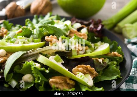 Frischer Waldorfsalat mit Salat, grünen Äpfeln, Walnüssen und Sellerie auf Holztisch. Stockfoto