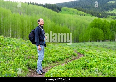 Mann stehend mit Rucksack auf dem Snodgrass Trail mit Bokeh-Hintergrund Blick auf Espenwald in Mount Crested Butte, Colorado im Sommer Stockfoto