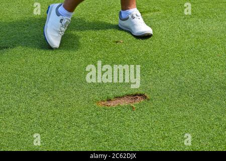 Junger Mann, der einen Dipot im Laufe eines Schlaganfalls aus dem Boden geschnitten hat. Stockfoto