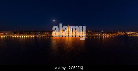 Panorama-Luftdrohne Aufnahme der Fassade des ungarischen Parlaments mit Licht in Budapest Nacht Stockfoto