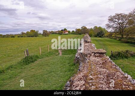 Die prächtige römische Mauer in Silchester (Calleva Atrebatum), in der Nähe von Basingstoke, England, erstreckt sich in die Ferne Stockfoto