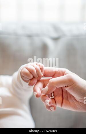 Baby hält den Finger der Mutter. Nahaufnahme Stockfoto