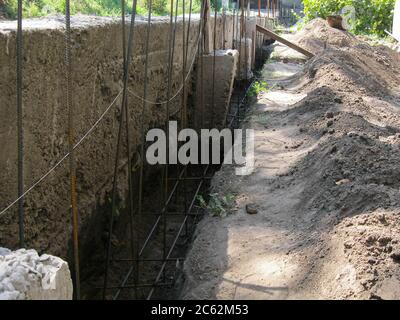 Langer Betongraben für Fundament. Der Bau des Zauns. Stockfoto