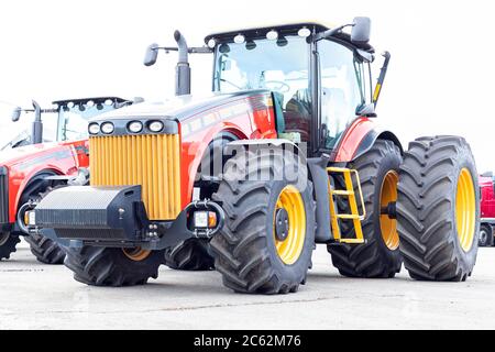 Großer landwirtschaftlicher Traktor auf weißem Hintergrund. Ausrüstung für die Kultivierung des Landes. Nahaufnahme. Stockfoto