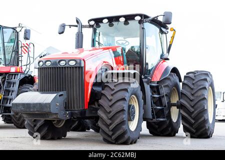 Großer landwirtschaftlicher Traktor auf weißem Hintergrund. Ausrüstung für die Kultivierung des Landes. Seitenansicht. Nahaufnahme. Stockfoto